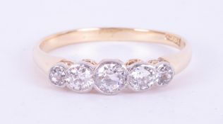 An 18ct yellow & white gold five stone rub over ring set with five round brilliant cut diamonds,