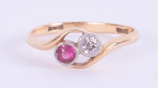 An 18ct yellow gold crossover style ring set with a round cut diamond and ruby, 2.56gm, size N.