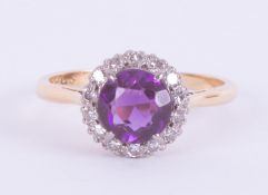 An 18ct yellow gold & platinum cluster ring set with a central round cut amethyst, approx. 1.50