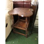 STAINED OAK TWO-TIER TABLE WITH A QUATREFOIL SHAPED TOP WITH EMBOSSED LEATHER WORK CHEQUERBOARD