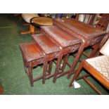 NEST OF FOUR FAR EASTERN STYLE OCCASIONAL TABLES WITH EXTENSIVE CARVED PATTERNING.