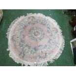 PALE PINK GROUND FLORAL PATTERNED EMBOSSED CIRCLE FLOOR RUG WITH TASSELED EDGE.