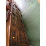 A LARGE STAINED OAK SIDEBOARD WITH FOUR DRAWERS OVER FOUR CUPBOARD DOORS WITH LINENFOLD PANELS AND