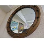 Circular convex wall mirror in a gilt effect frame.