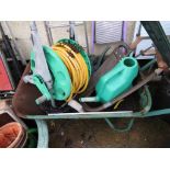 A WHEELBARROW, A LARGE GREEN PLASTIC PLANTER AND VARIOUS GARDENING TOOLS, INCLUDING WATERING CANS,
