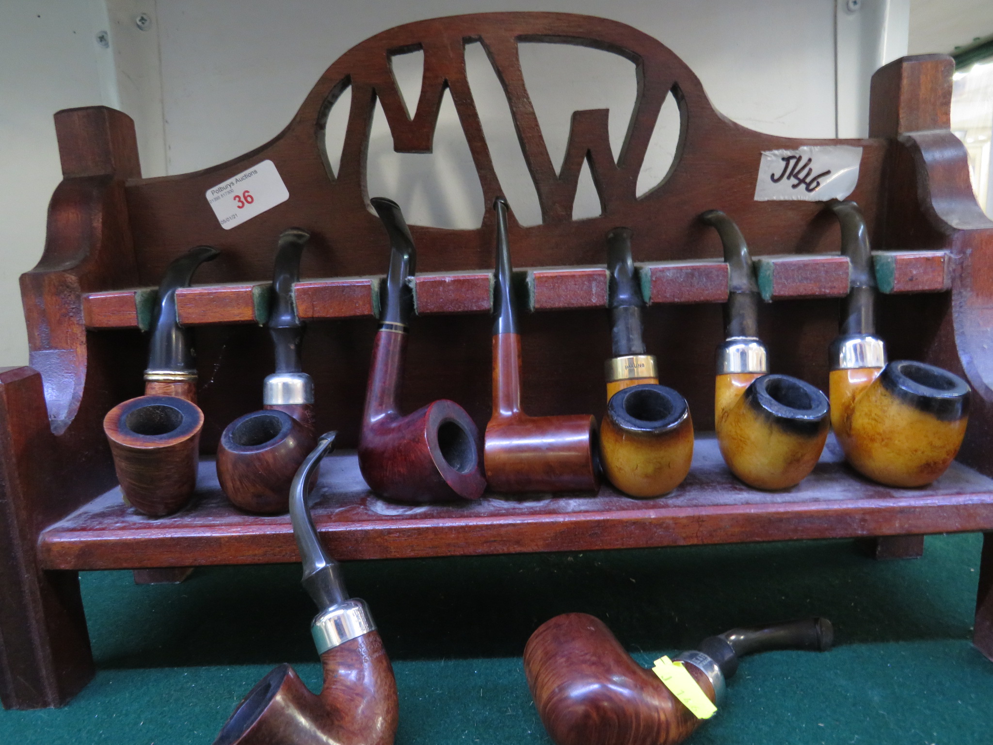Nine vintage tobacco pipes including K & P, Torino, and a wooden pipe rack carved with initials