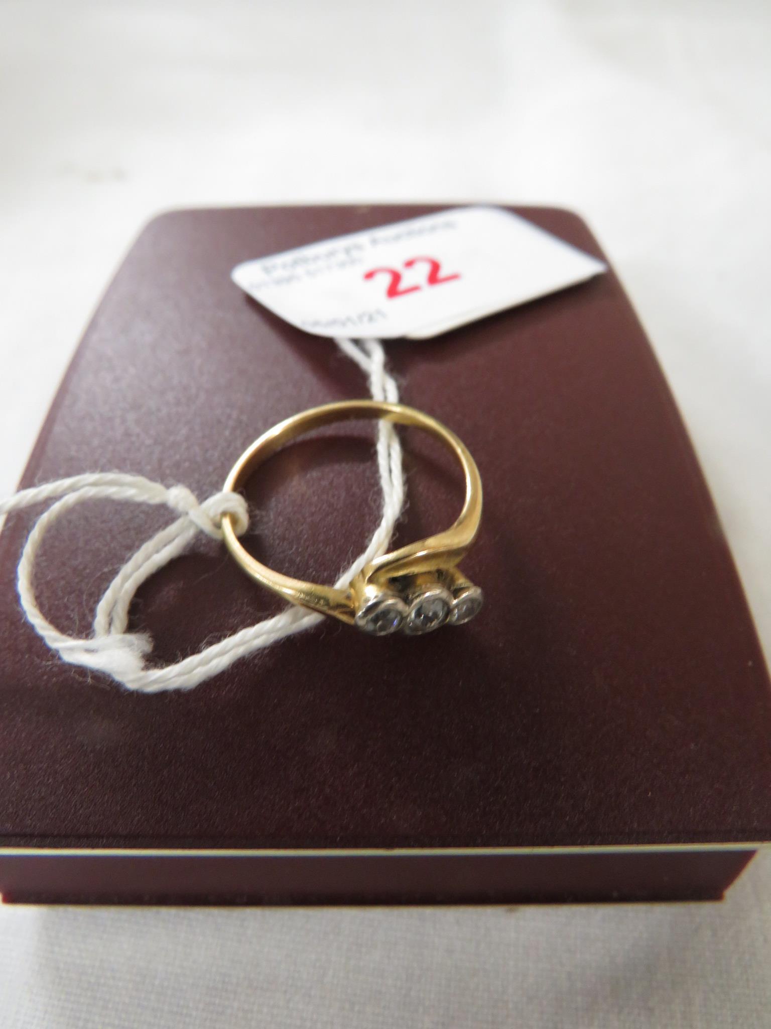 Yellow metal ring set with three small white stones in crossover setting, gross weight of ring 2.5g,