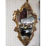 CARTOUCHE SHAPED WALL MIRROR IN A DECORATIVE GILT EFFECT FRAME