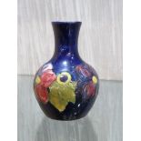 SMALL MOORCROFT POTTERY BOTTLE VASE, BLUE GROUND WITH TUBELINED DECORATION OF PURPLE FLOWERS, SIGNED