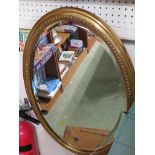 OVAL BEVELLED EGDE WALL MIRROR IN GILT EFFECT FRAME.