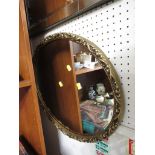 OVAL WALL MIRROR IN GILT FRAME.