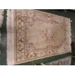 A CHINESE WOOL RECTANGULAR EMBOSSED RUG, BEIGE GROUND WITH TYPICAL PATTERNING. (AF)