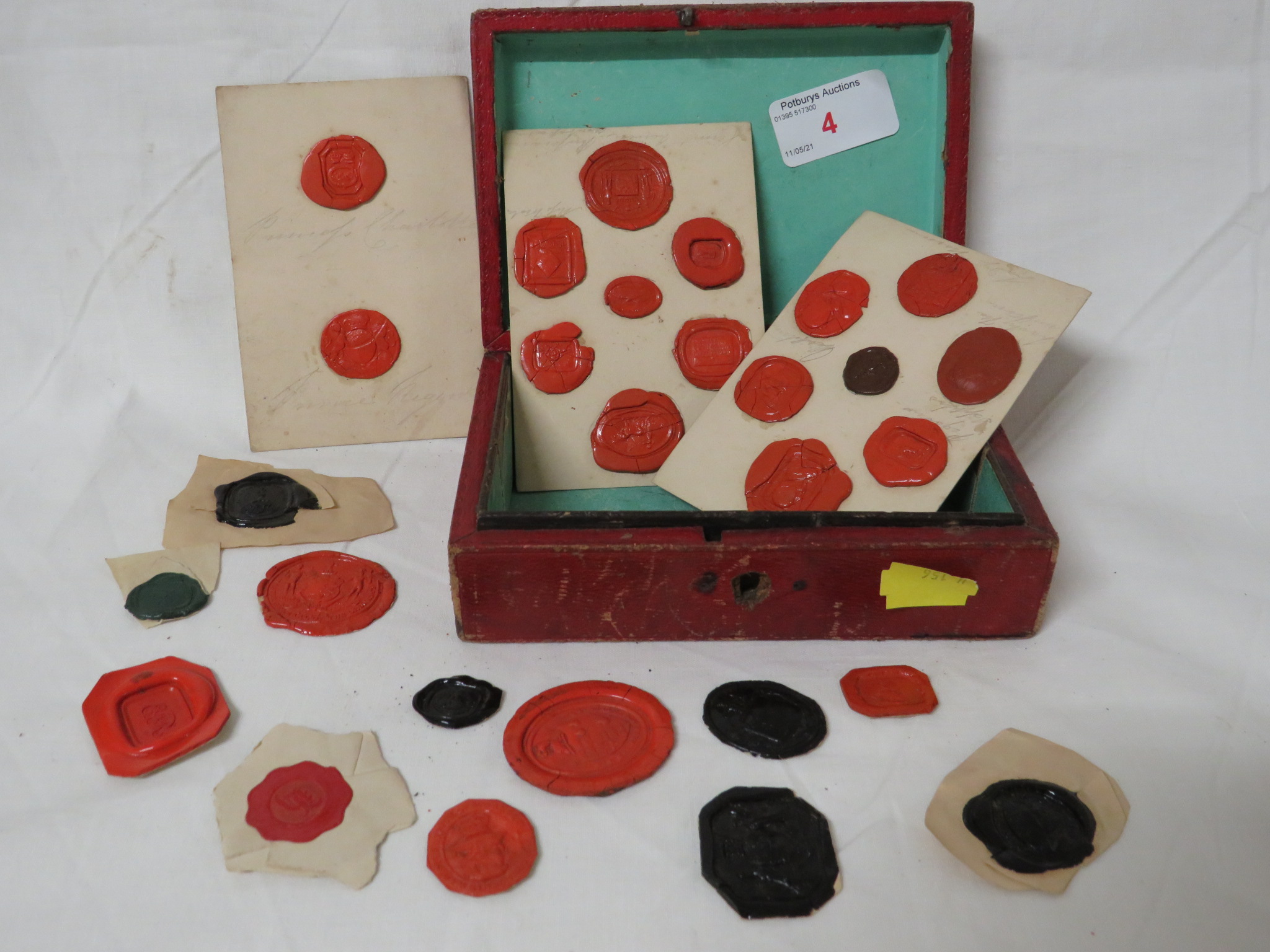 SELECTION OF ANTIQUE FOB SEAL IMPRESSIONS IN A LEATHER CLAD BOX.