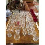 AN ASSORTMENT OF GLASS DRINKING VESSELS INCLUDING WINE AND ETCHED GLASSES ETC.