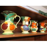 FOUR DEVON WARE FIELDINGS DECORATIVE JUGS IN GREEN, YELLOW AND ORANGE