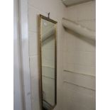 LONG RECTANGULAR WALL MIRROR IN A GILT EFFECT FRAME.