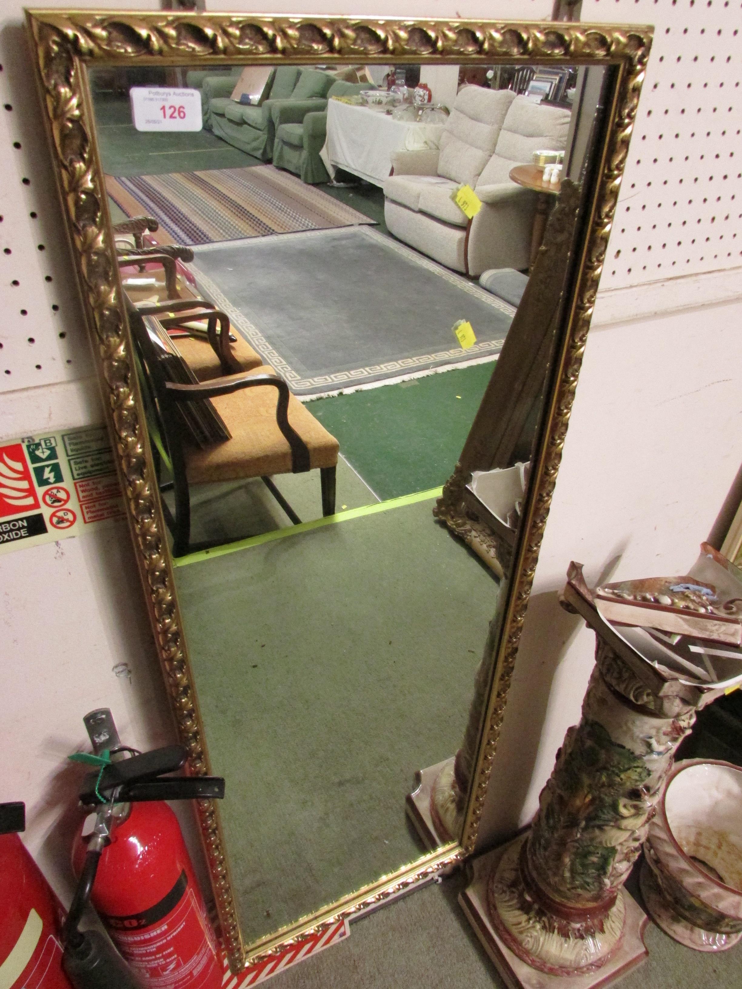 LONG RECTANGULAR WALL MIRROR IN A GILT EFFECT FRAME.