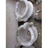 PAIR OF COMPOSITE STONE TWO HANDLED GARDEN URNS ON PLINTHS