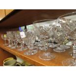 ONE SHELF OF CRYSTAL STEMMED DRINKING GLASSES. INCLUDING STUART GLASS.