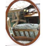 OVAL MIRROR IN MAHOGANY FRAME .