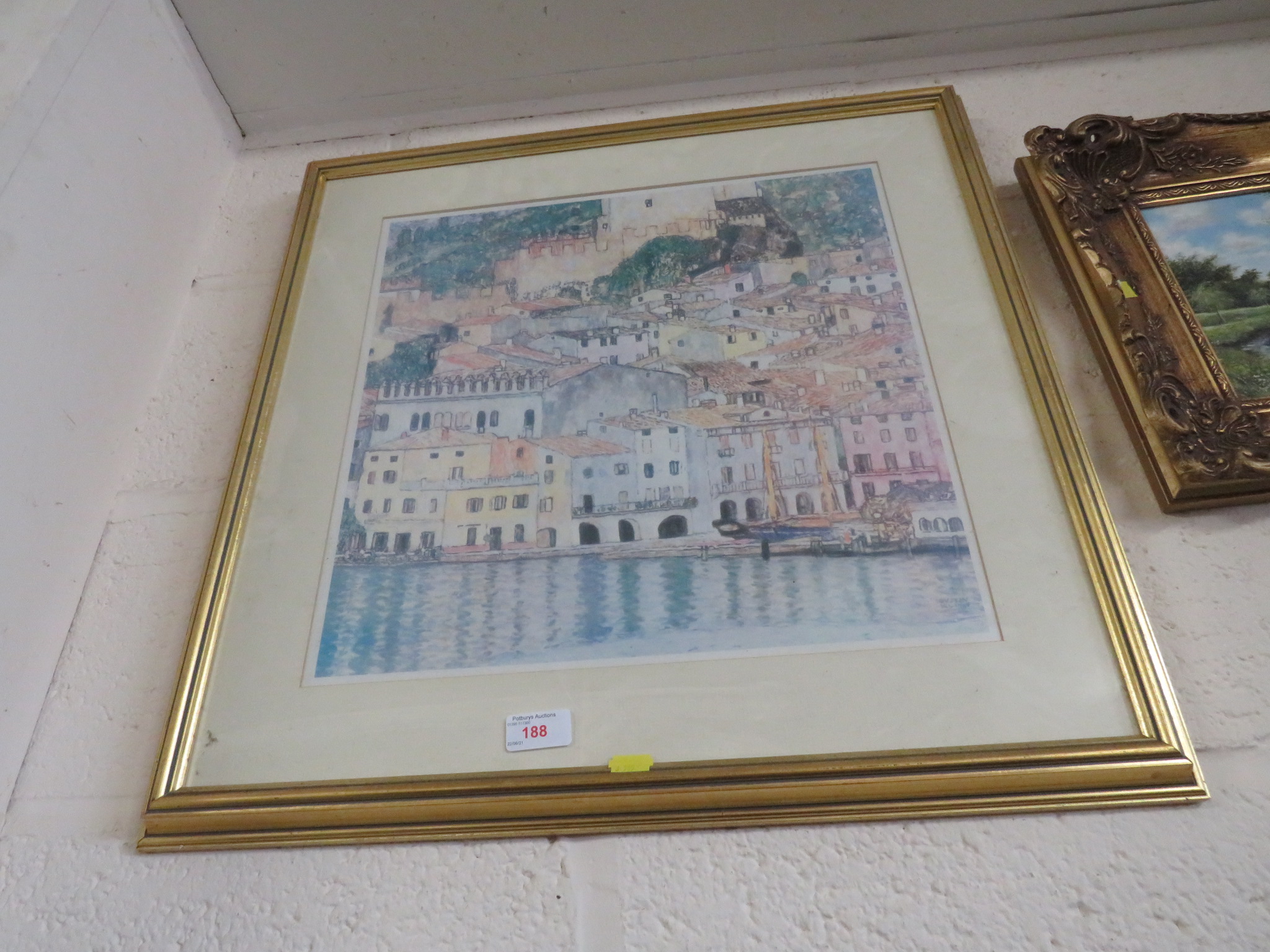 FRAMED AND GLAZED COLOURED PRINT OF TROPICAL BUILDINGS.