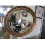 OVAL BEVEL EDGED MIRROR IN A GOLD PAINTED FRAME.