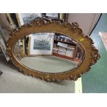 OVAL BEVEL EDGED MIRROR IN A GILT WOODEN FRAME.