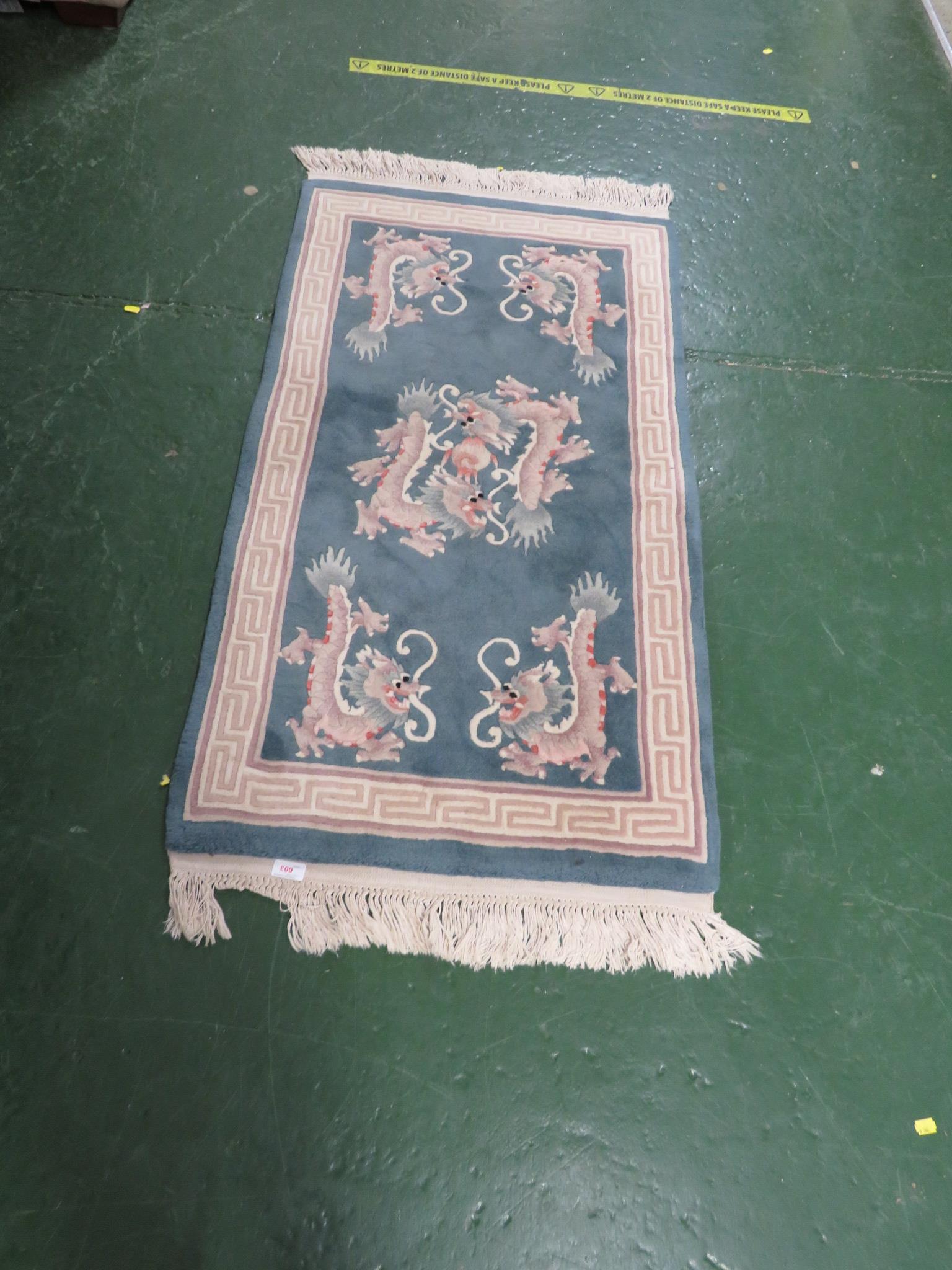 BLUE GROUND EMBOSSED CHINESE STYLE RUG DECORATED WITH DRAGONS. 125 CM BY 68 CM