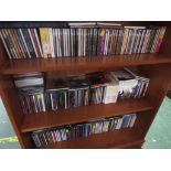 THREE SHELVES OF POP , ROCK , CLASSICAL CDS.