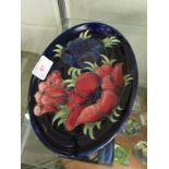 MOORCROFT POTTERY SHALLOW OVAL DISH DECORATED WITH FLOWERS , SIGNATURE TO BASE.