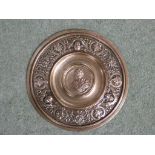 EMBOSSED BRASS ROUNDEL, PERHAPS MADE FROM A RECLAIMED SHELL CASING