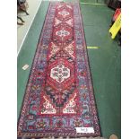 LOUIS DE POORTERE KARIJAN WOOLLEN BLUE AND RED GROUND THREE MEDALLION FLOOR RUNNER.