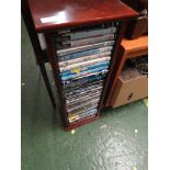 WOOD EFFECT DVD RACK WITH CONTENTS OF DVDS.