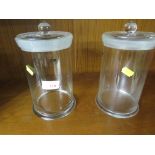 PAIR OF GLASS LIDDED STORAGE JARS.