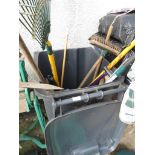 A BLACK WASTE BIN WITH CONTENTS OF GARDENING TOOLS.