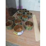 TWELVE ENAMELLED BRASS NAPKIN RINGS.