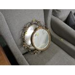 A CIRCULAR TABLE MIRROR IN A GILT EFFECT FRAME, AND A WALL MIRROR IN A BRASS FRAME.