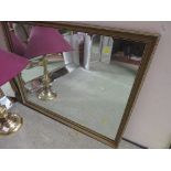 RECTANGULAR WALL MIRROR IN A GOLD COLOURED FRAME.