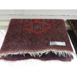 RED GROUND MIDDLE EASTERN RUG WITH FIVE MARGINS AND THREE MEDALLIONS 132 BY 85 CM