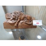 CARVED WOODEN FIGURE OF A VANQUISHED LION WITH LATIN MOTO.
