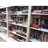 ELEVEN SHELVES OF PAPERBACK FICTION OF BOOKS.