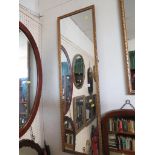 LONG RECTANGULAR WALL MIRROR IN A GILT EFFECT FRAME.