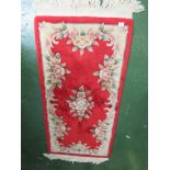 RED GROUND FLORAL PATTERNED RUG.