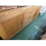 LIGHT OAK VENEERED SIDEBOARD WITH TWO CUPBOARD DOORS AND THREE CENTRAL DRAWERS.