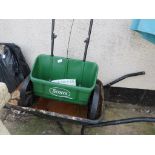 SCOTTS EVERGREEN DROP SPREADER TOGETHER WITH A METAL WHEELBARROW. (AF)