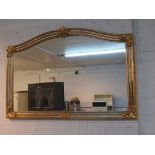 A LARGE ARCHED TOPPED RECTANGULAR MIRROR IN A GOLD PAINTED GILT EFFECT FRAME.