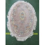 PINK GROUND OVAL FLOOR RUG WITH TASSEL EDGE.