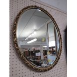 OVAL BEVELLED EDGED MIRROR IN A GILT EFFECT FRAME.