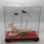 A presentation oriental metal ship in display case: Possibly Silver plate presented to Captain P