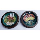 Moorcroft framed coasters: one decorated with cherries and the other 1897-1997 centenary,